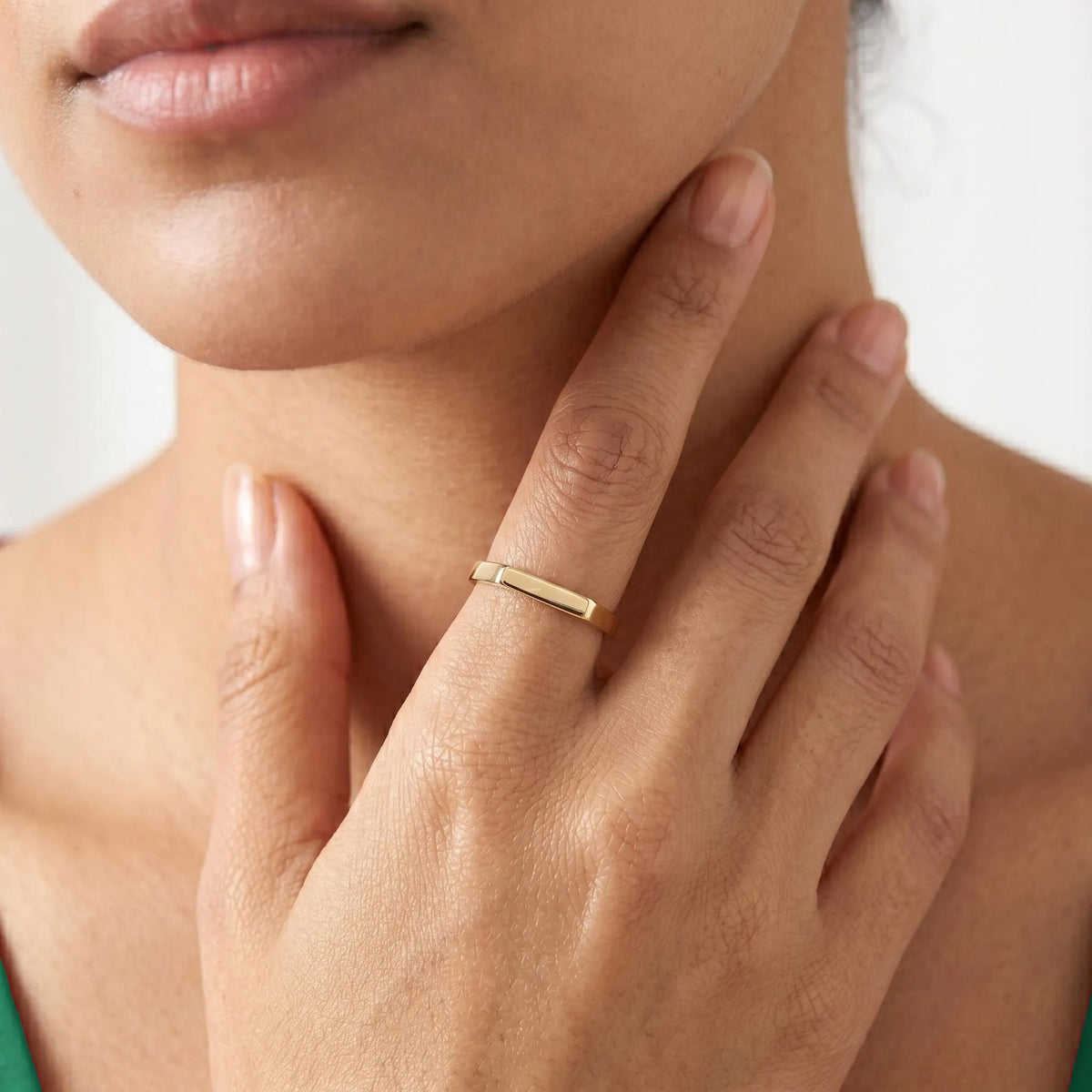 Slim gold bar ring worn on hand