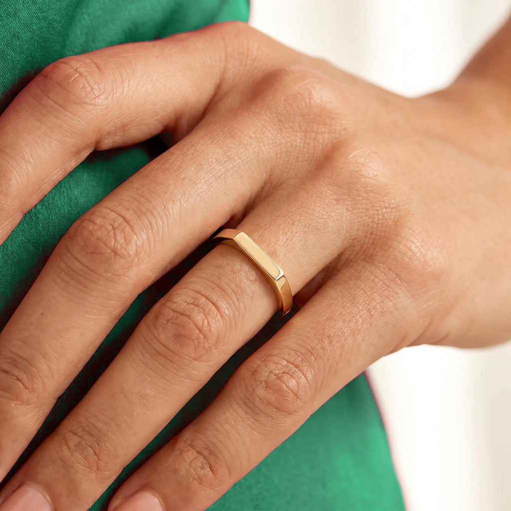Gold rectangle pinky ring on hand