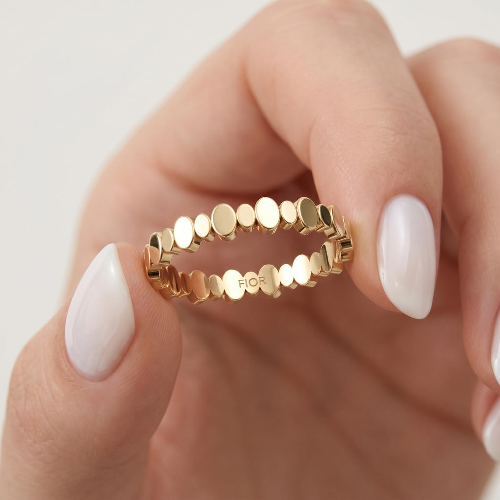 Beaded gold ring held between fingers