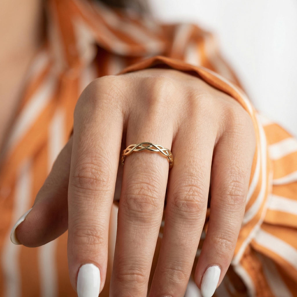 Braided gold wedding band on finger