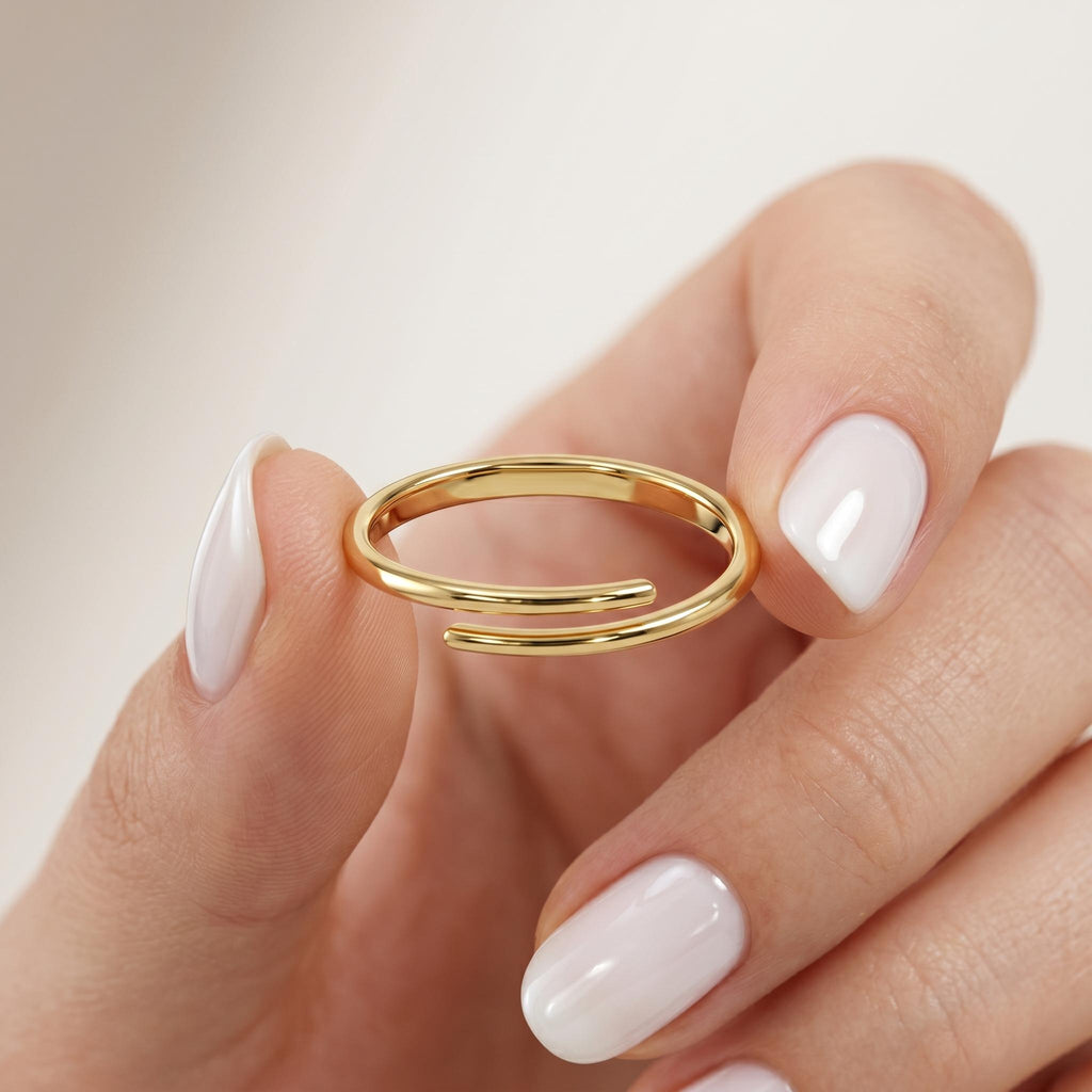 Solid gold criss cross ring held between fingers