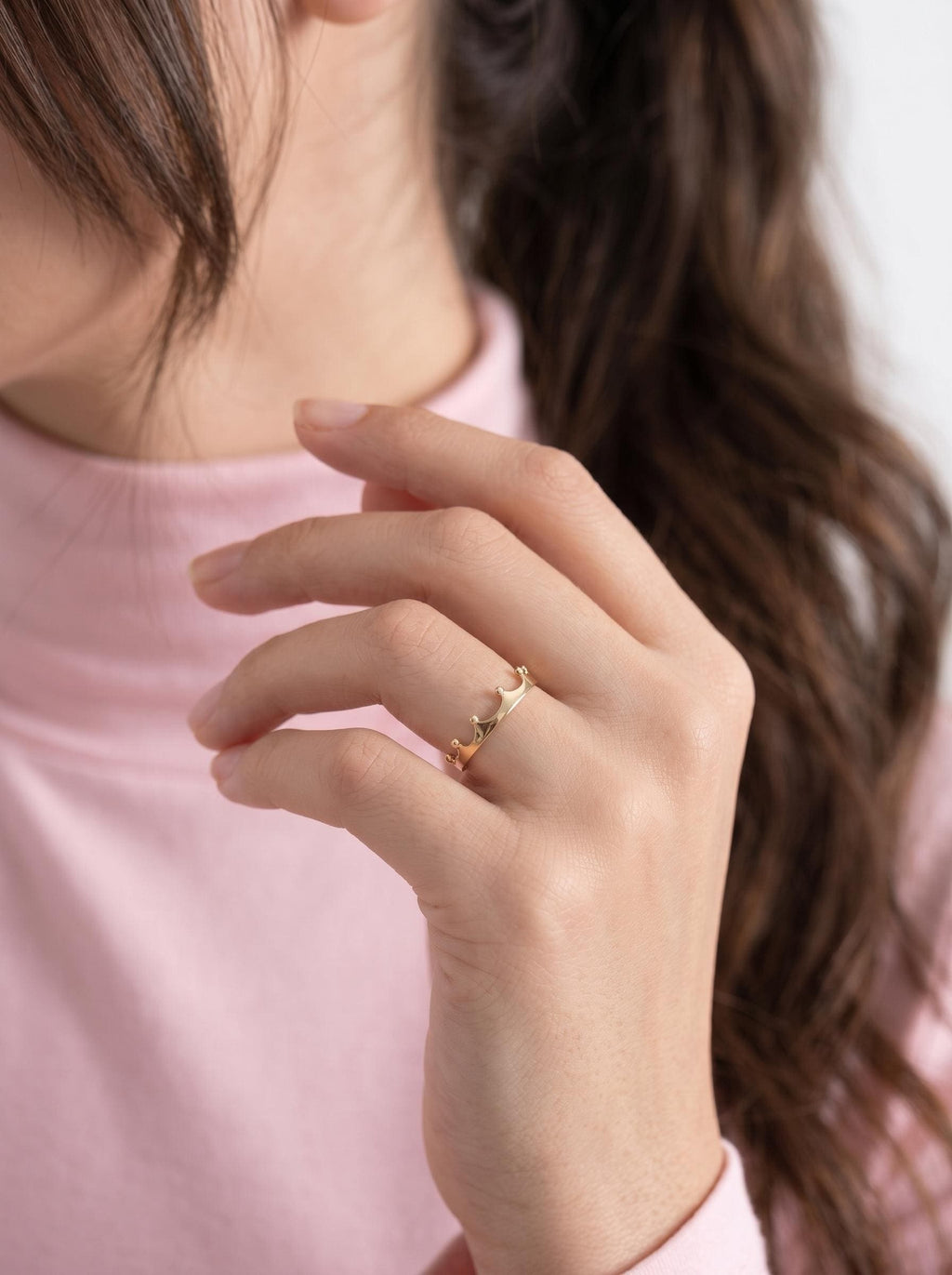 Dainty gold crown ring worn on hand
