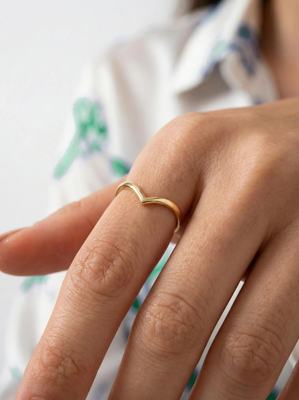 Gold V shape wishbone ring worn on hand