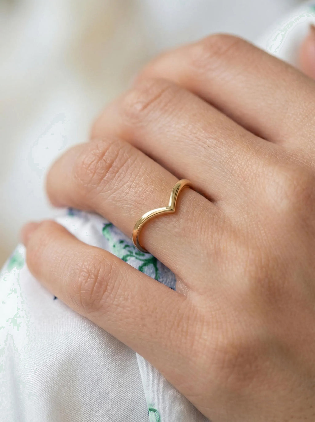 Dainty gold chevron ring on finger