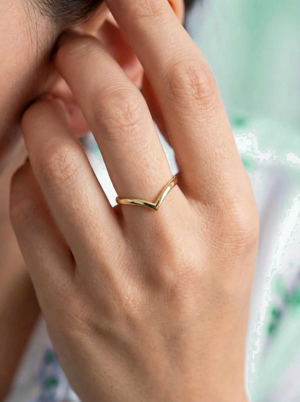 Gold V ring worn close to the face