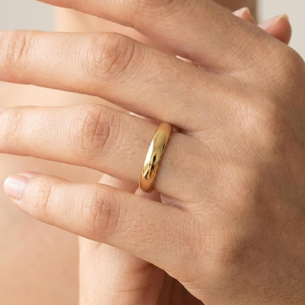 Classic gold wedding band worn on hand
