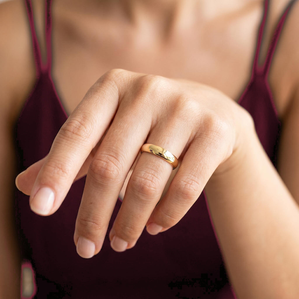 Polished gold wedding ring on finger