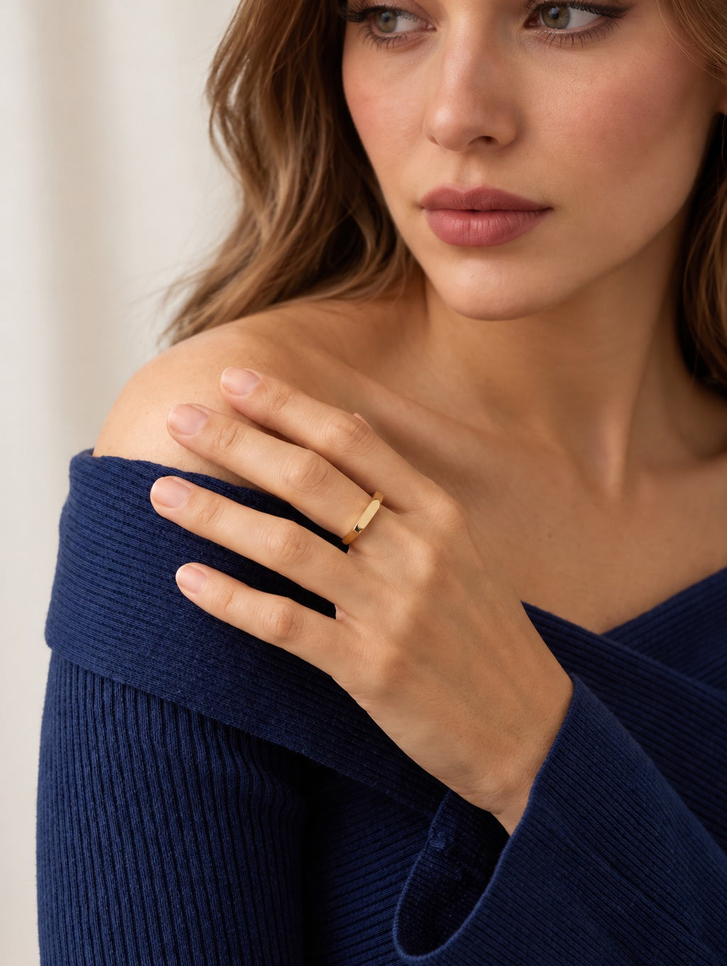 Model wearing the 14k gold edge ring with her hand on her shoulder