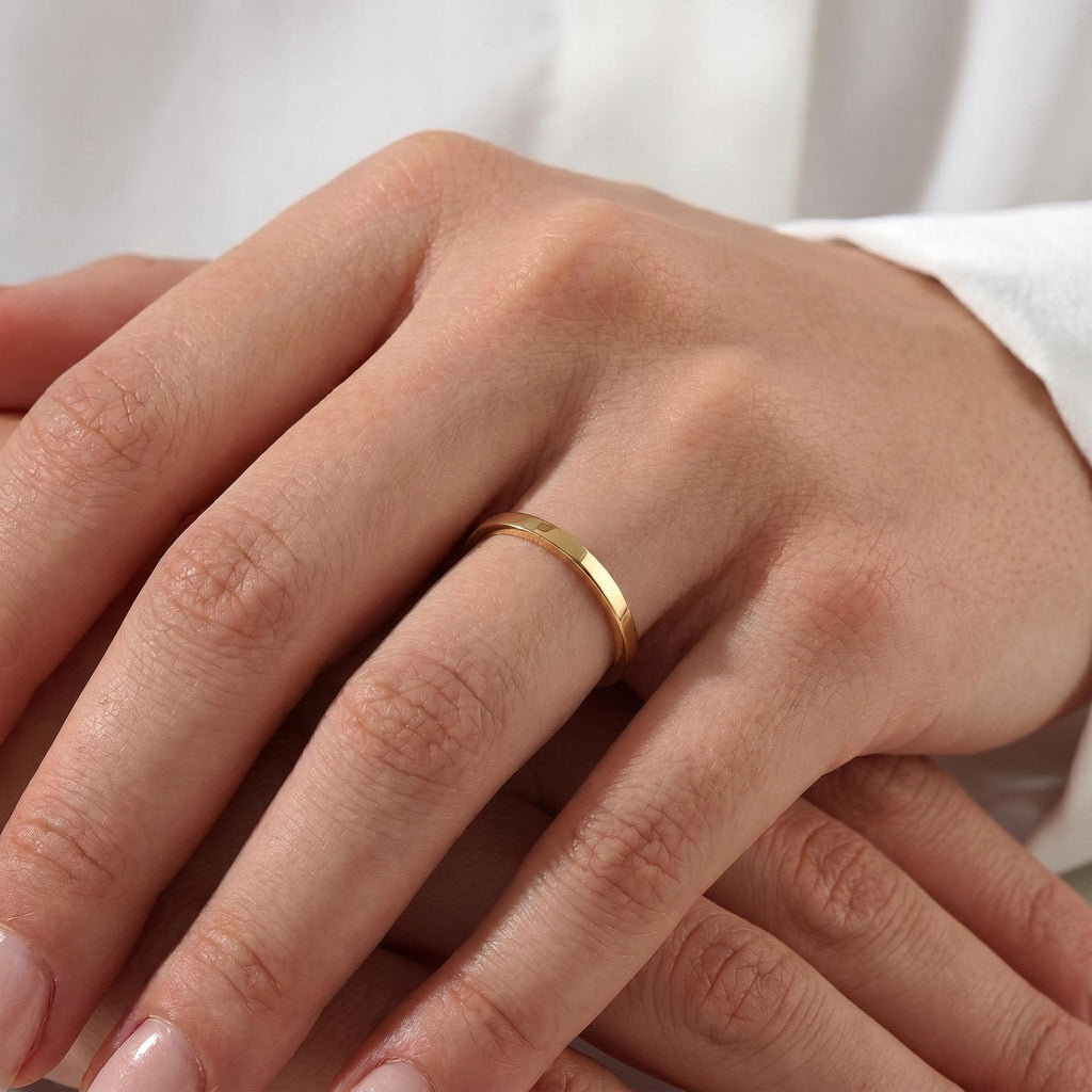 Thin gold wedding band worn on hand