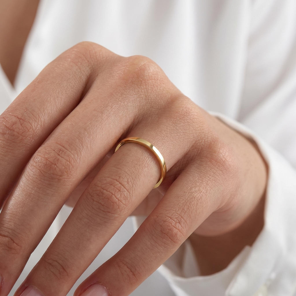 Plain gold wedding ring worn on finger