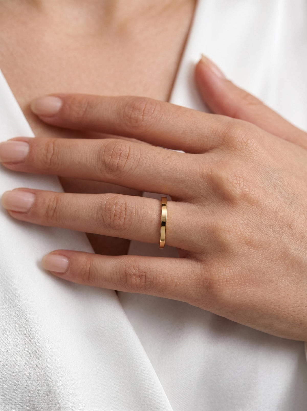 Gold flat band worn on hand