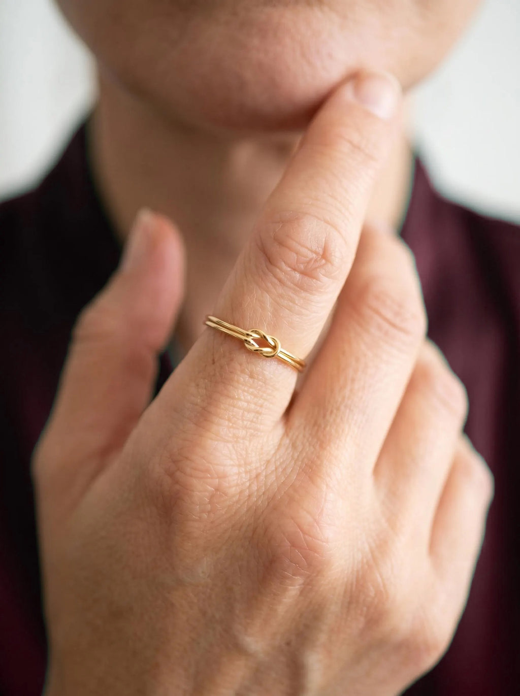 Gold knot ring worn close to the face