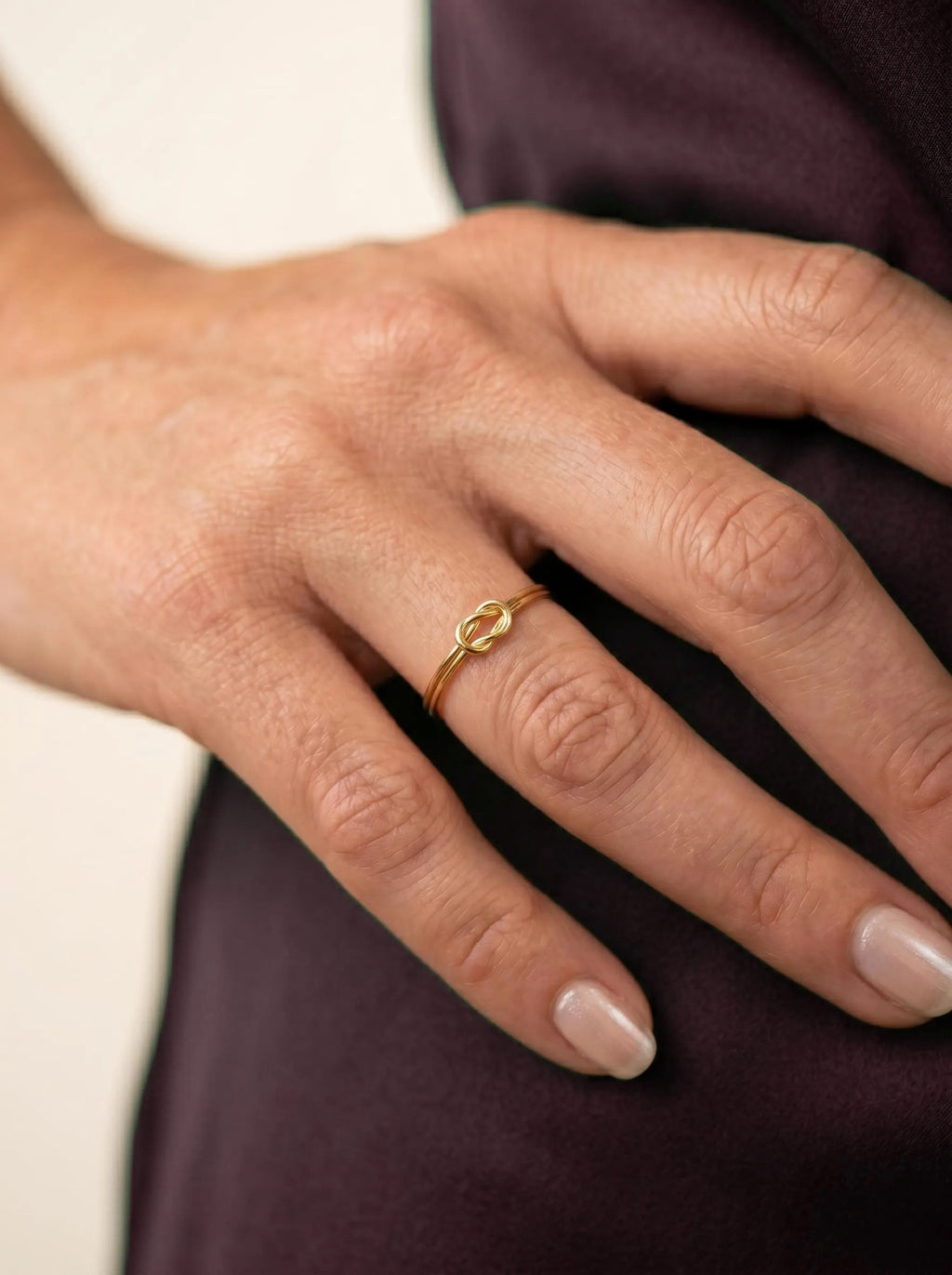 Minimalist gold knot ring on hand