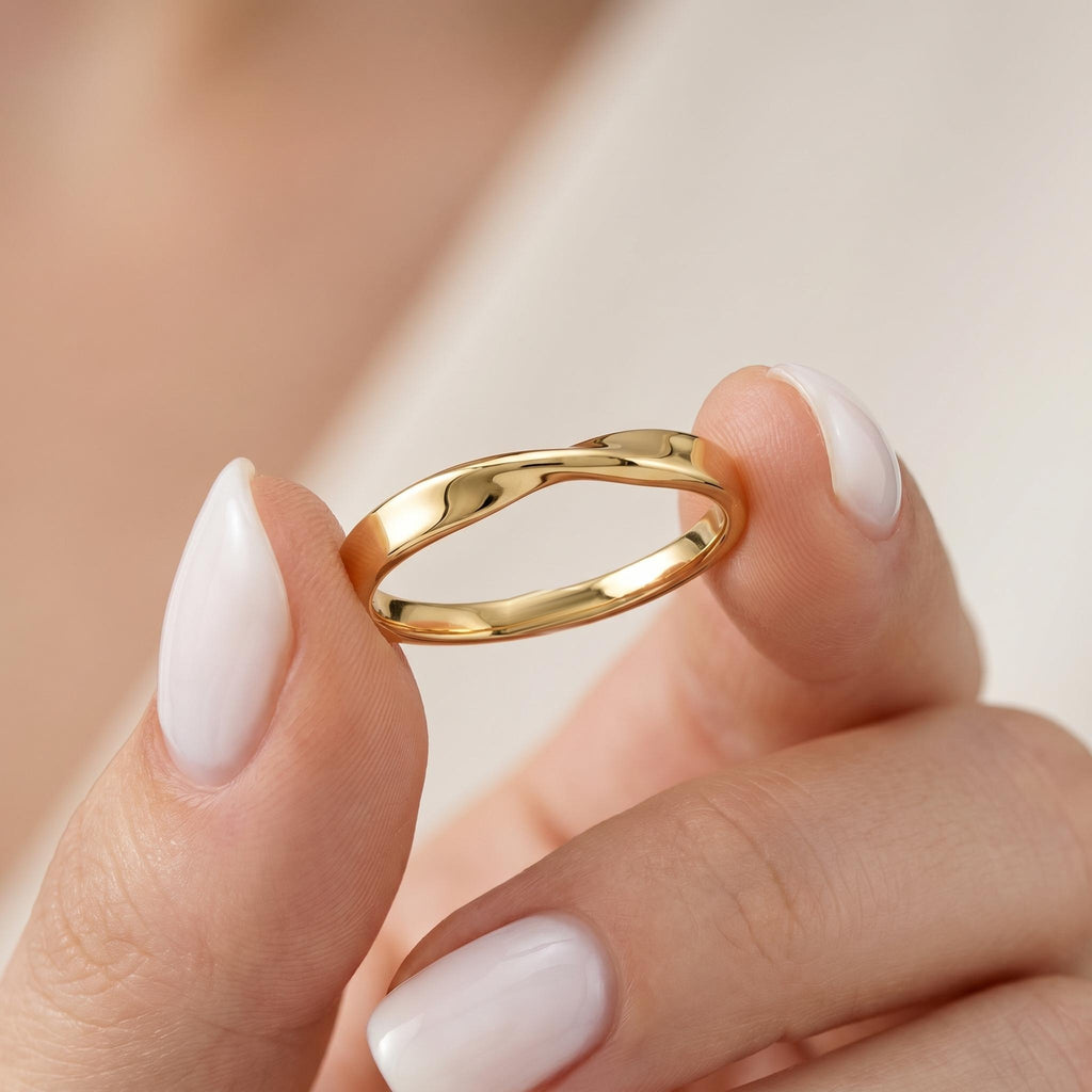 Gold Mobius twist band held between fingers