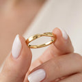 Gold Mobius twist band held between fingers