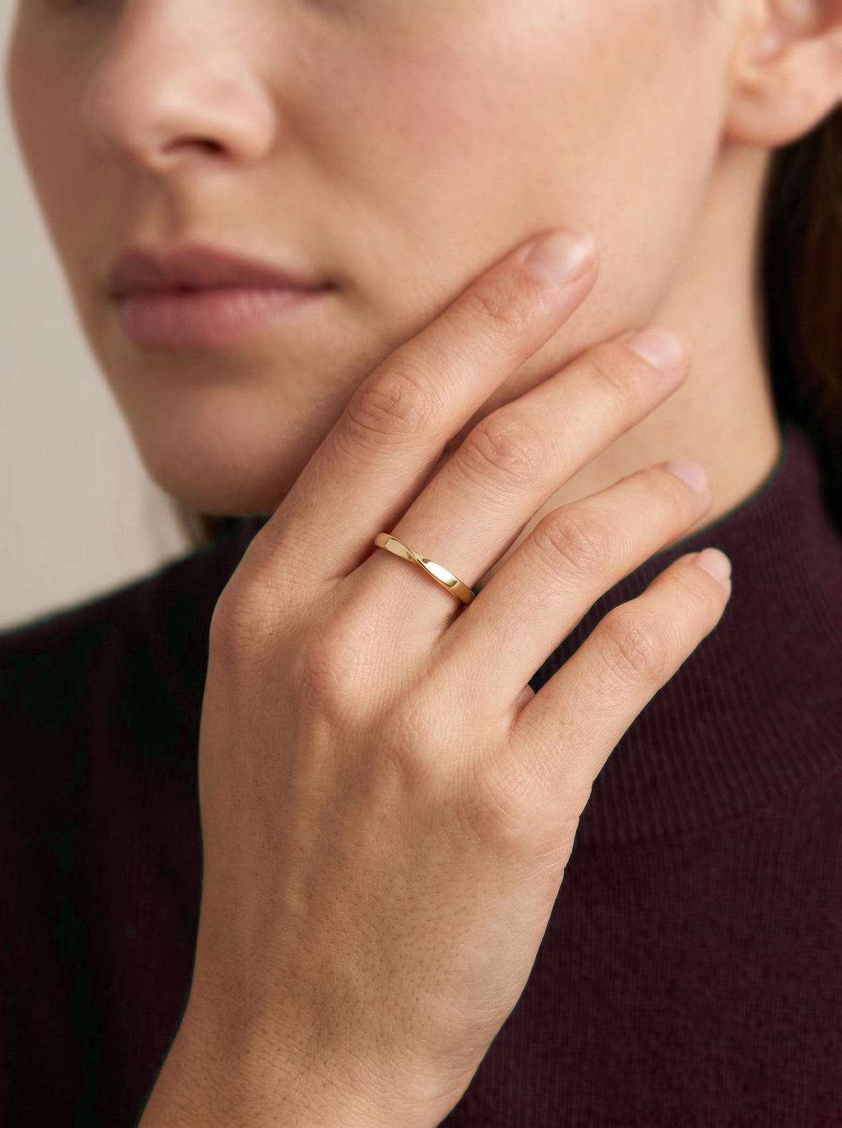 Mobius twist wedding band worn on hand near the face