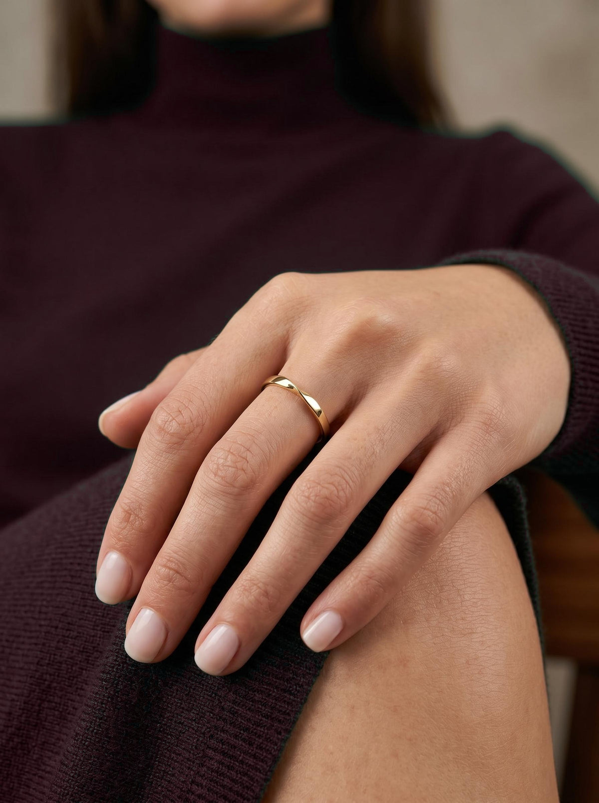 Solid gold twist wedding band on hand