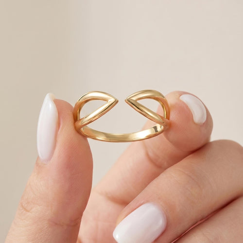 Gold open ring held between fingers