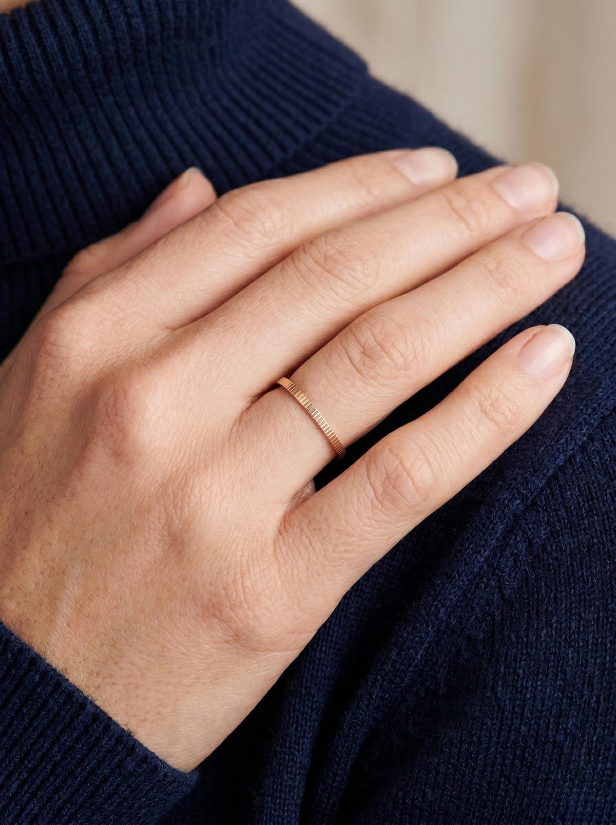 Thin ribbed gold band worn