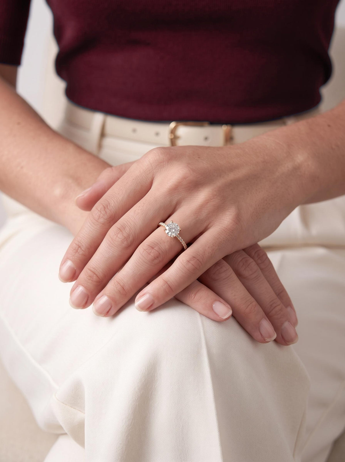 Engagement ring worn with hands resting on the knee