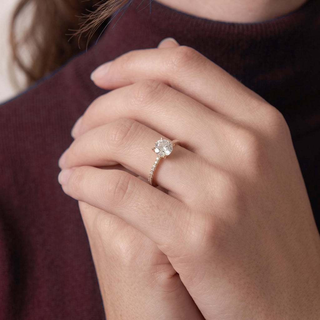Round diamond engagement ring worn with hands clasped